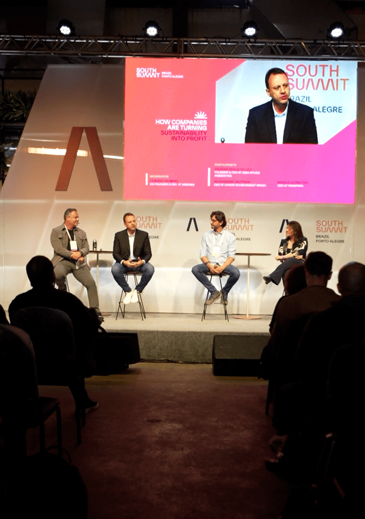 Painel de debate no South Summit Brazil Porto Alegre com quatro palestrantes sobre sustentabilidade e lucro