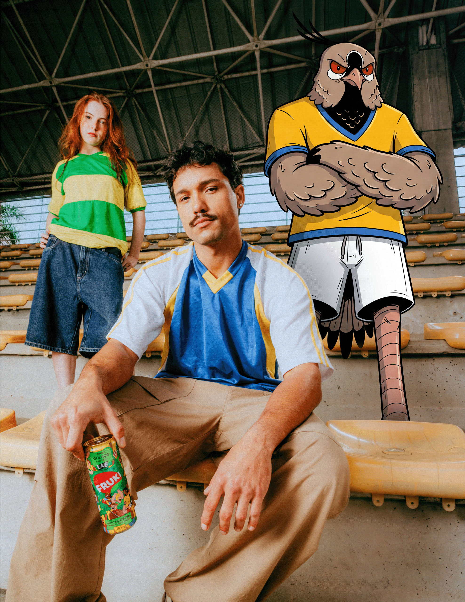 Peça da campanha Fruki Pipoca: mascote quero-quero ilustrada de braços cruzados e camisa amarela da seleção ao lado de dois modelos reais em arquibancada de estádio, um deles segurando lata da edição limitada Golaço Fruki Lab